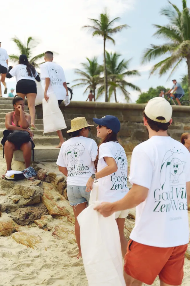Album do Voluntários recolhendo lixo na areia durante ação sustentável da Click Cannabis