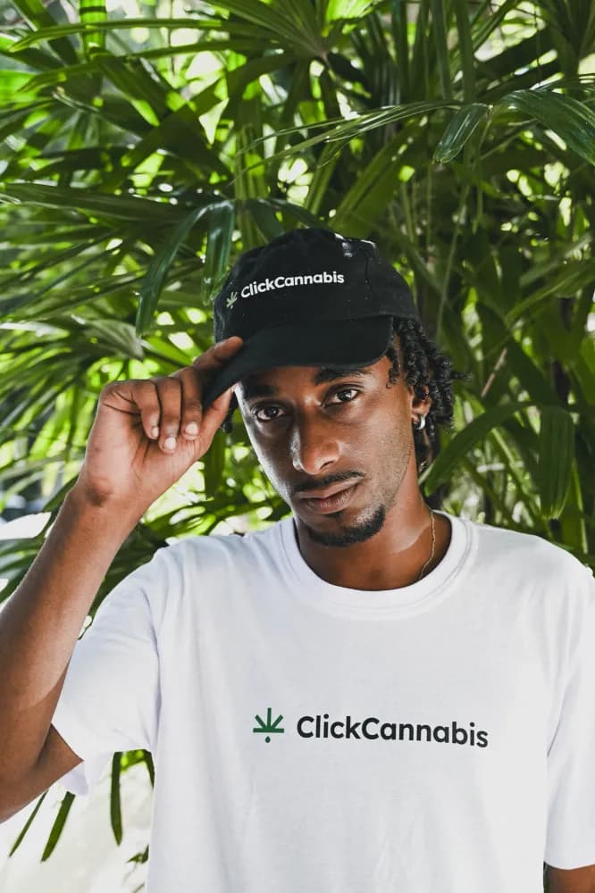 Album do Retrato com boné Click Cannabis em meio à vegetação urbana
