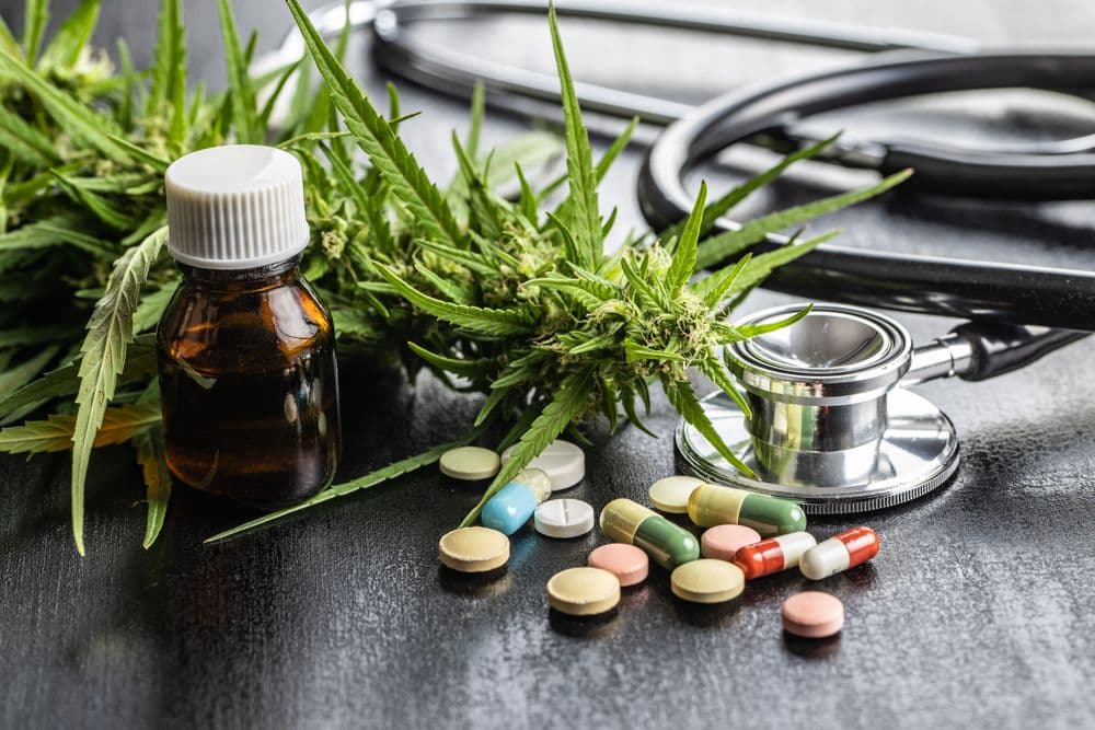 Cannabis medicinal, óleo terapêutico, estetoscópio e medicamentos farmacêuticos. 